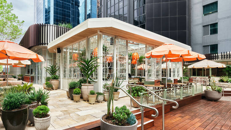 The exterior of Rafio with orange umbrellas and green plants