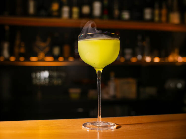 A yellow cocktail on a wooden table